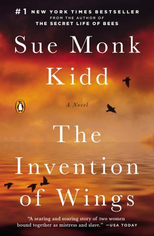 The Invention of Wings book cover done in oranges of calm water and a cloudy sky with the shadows of a few black birds flying around